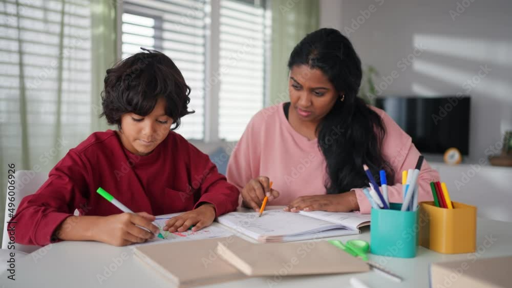 Little multiracial boy doing homework with his mother at home. Little multiracial boy doing homework with his mother at home.