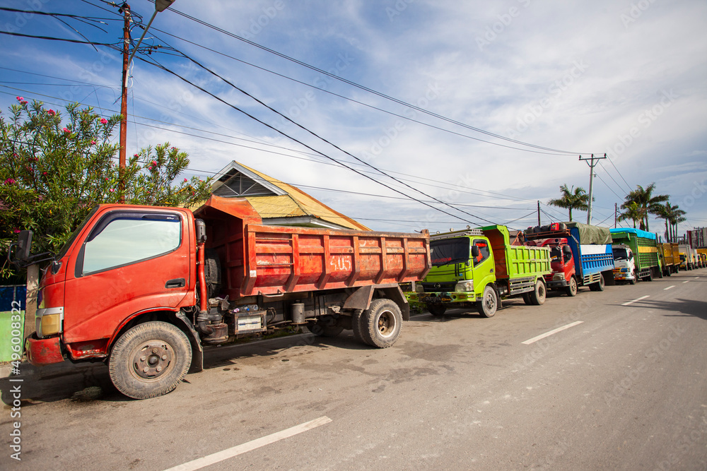 Obraz premium Trucks queue to refuel near a gas station in Palu City, Central Sulawesi, Indonesia. These trucks deliver various goods to cities in Central Sulawesi Province.