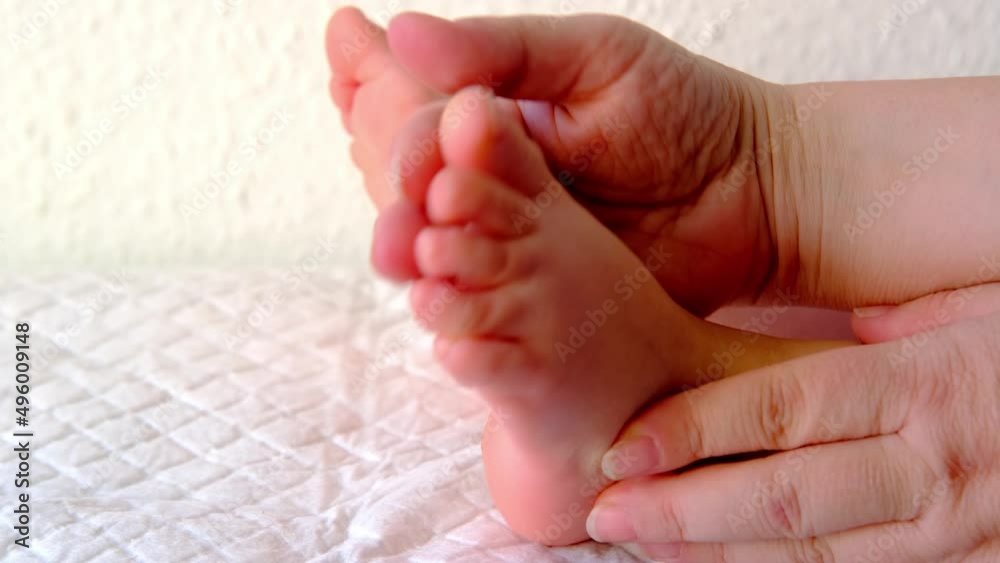 close-up baby's bare feet, female hands gently knead the child's legs, make therapeutic, preventive massage, strengthen musculoskeletal system, stimulate physical development, prevention of flat feet close-up baby's bare feet, female hands gently knead the child's legs, make therapeutic, preventive massage, strengthen musculoskeletal system, stimulate physical development, prevention of flat feet