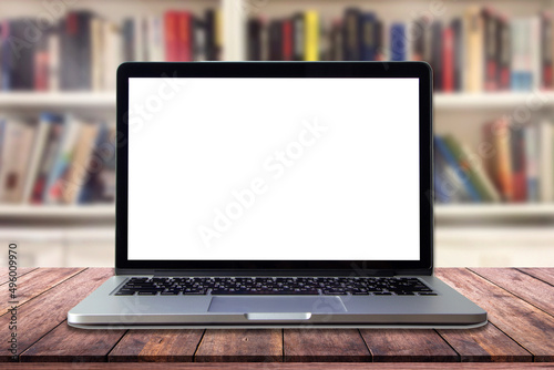 Laptop with blank screen on table in interior library