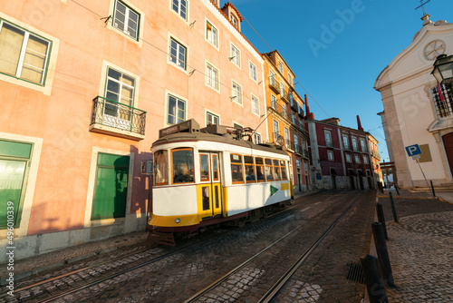 Sunny street of Lisbon with blurry classic tram 28 in motion. Portugal 
