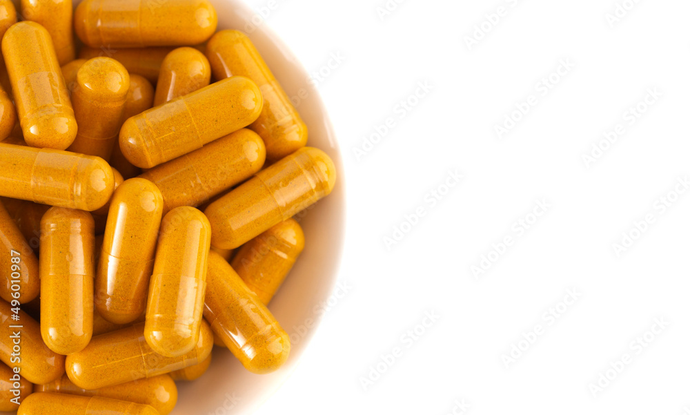 Ground Turmeric in Capsule form on a White Background Ground Turmeric in Capsule form on a White Background
