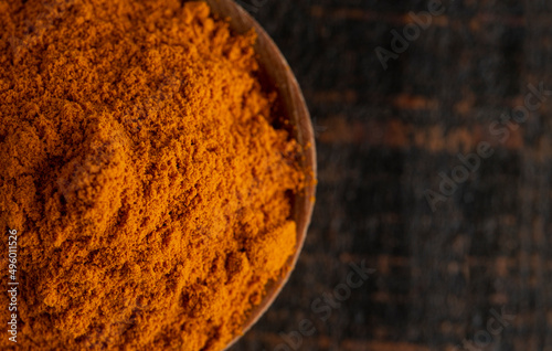 A Bowl of Ground Turmeric on a Wooden Table