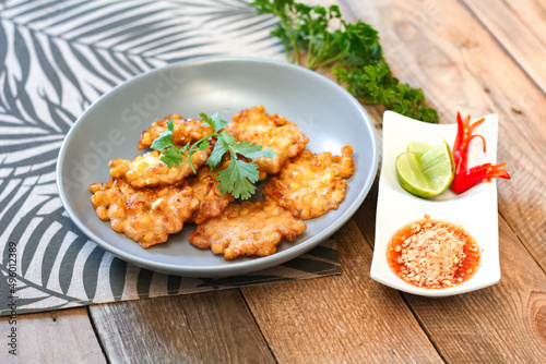 Corn Fritters With chili sauce placed on a wooden table