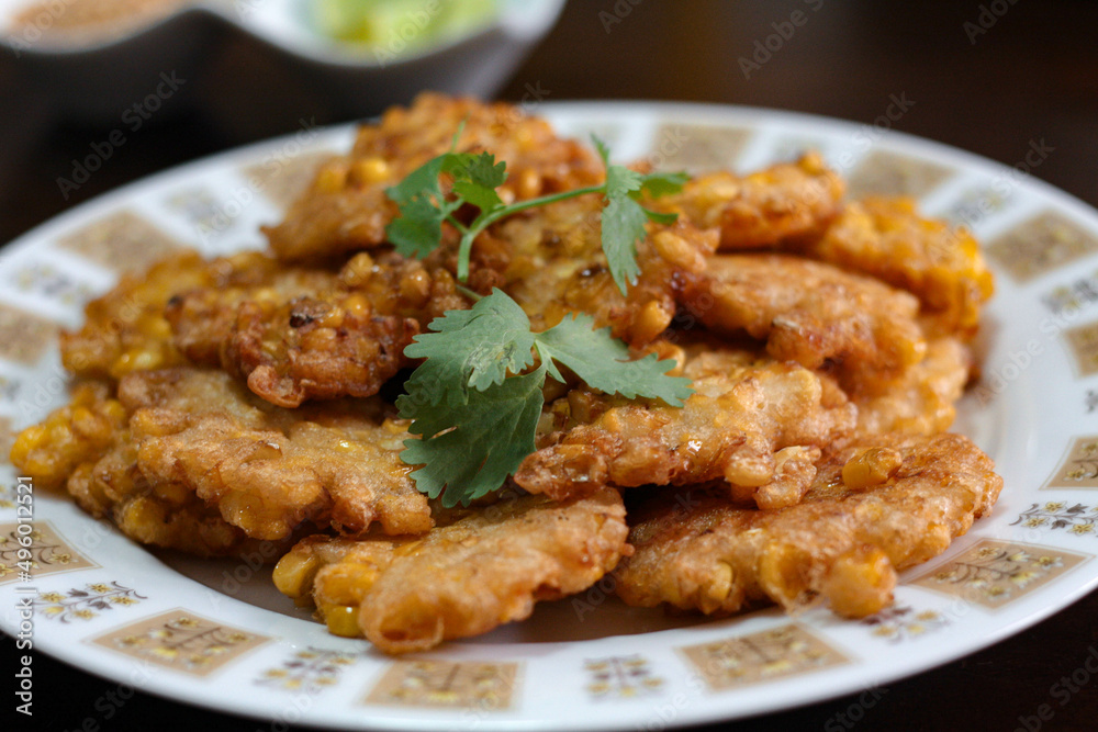 Corn Fritters With chili sauce placed on a wooden table Corn Fritters With chili sauce placed on a wooden table
