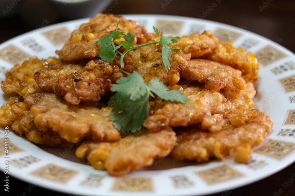 Corn Fritters With chili sauce placed on a wooden table Corn Fritters With chili sauce placed on a wooden table