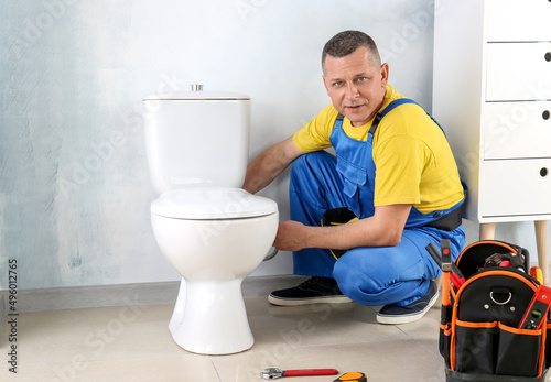 Plumber working in restroom