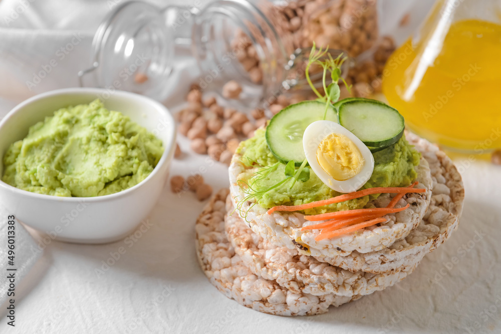 Crispbreads with tasty hummus on white background