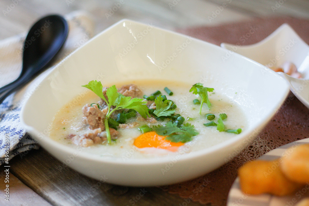 Chinese style porridge or porridge and fried dough stick or fried dough stick or donut or fried bread placed on a wooden table. Thai street food is called 