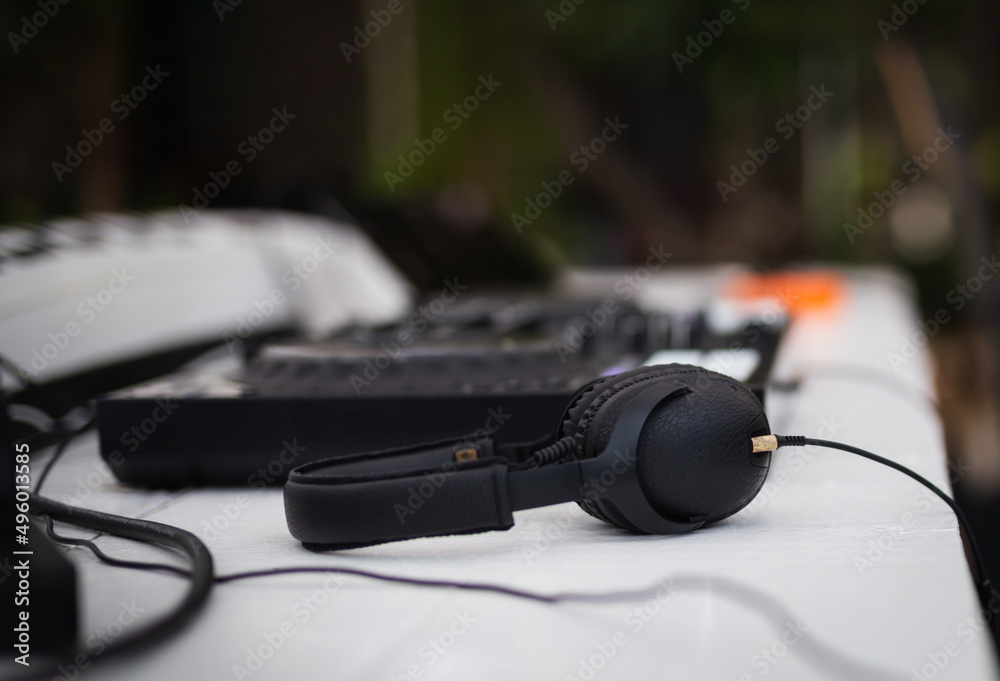 Black headphones and professional mixing console on table. Black headphones and professional mixing console on table.