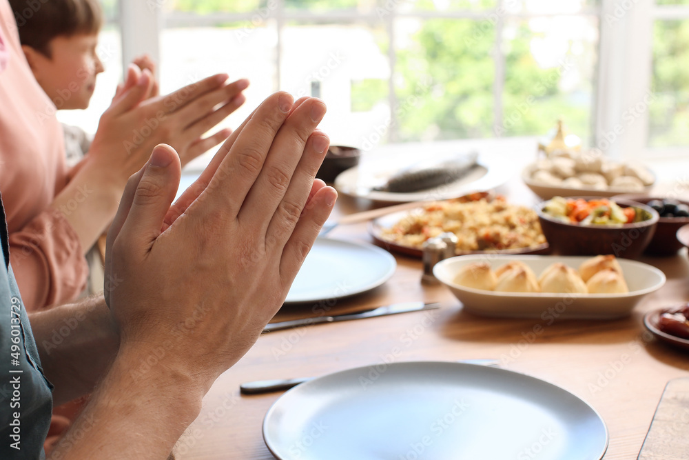 Muslim family praying together before breakfast. Celebration of Eid al-Fitr