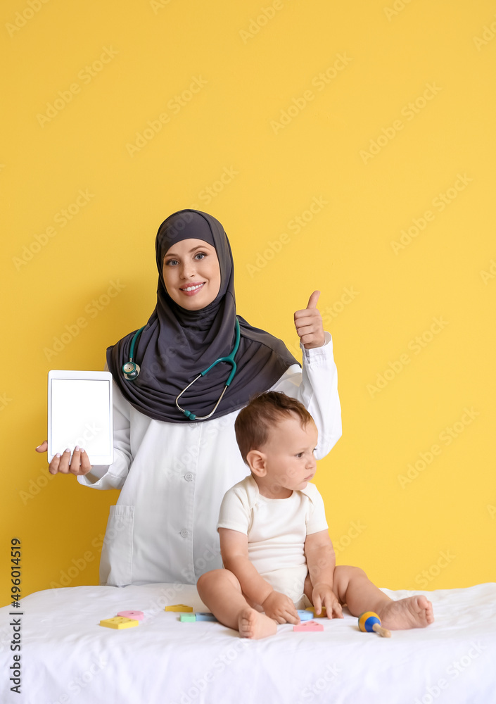 Muslim pediatrician with tablet computer and baby boy on color background Muslim pediatrician with tablet computer and baby boy on color background
