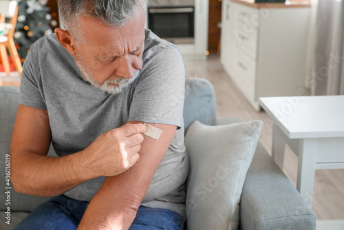 Mature man with applied nicotine patch at home. Smoking cessation photo