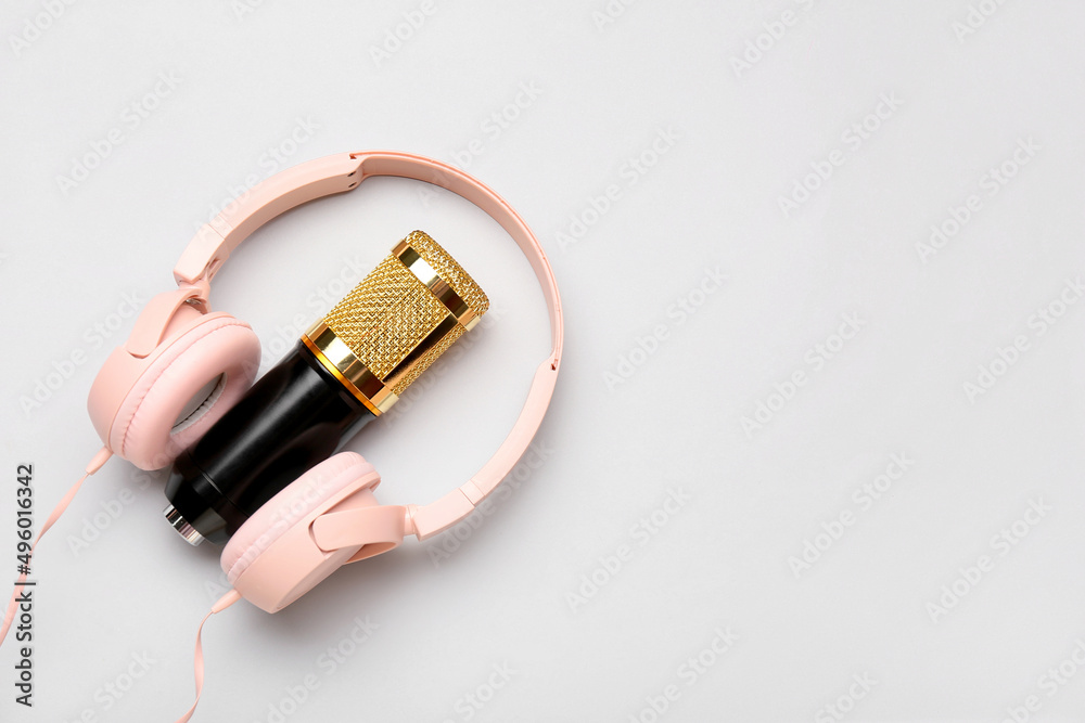 Headphones and modern microphone on light background Headphones and modern microphone on light background