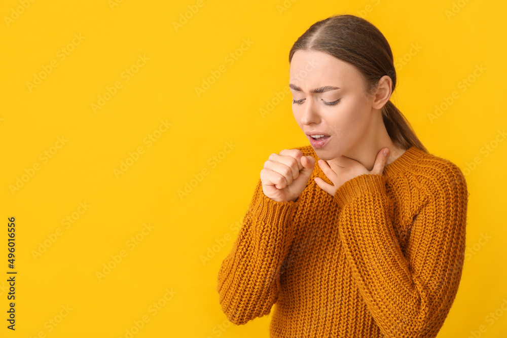 Ill coughing young woman with sore throat on yellow background Ill coughing young woman with sore throat on yellow background