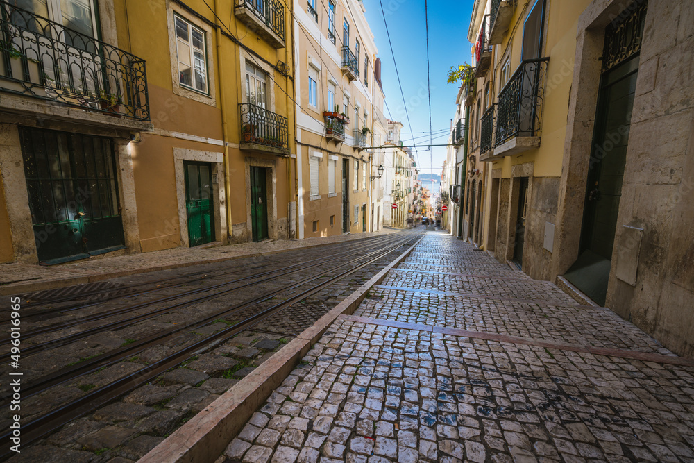 Tram tracks at the narrow street in the Lisbon, a detail metal rails ...