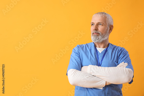 Mature male doctor on yello...