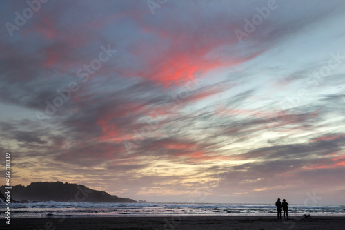 People walk on the beach at sunset in Mendocino County, along the California Coast, United States.