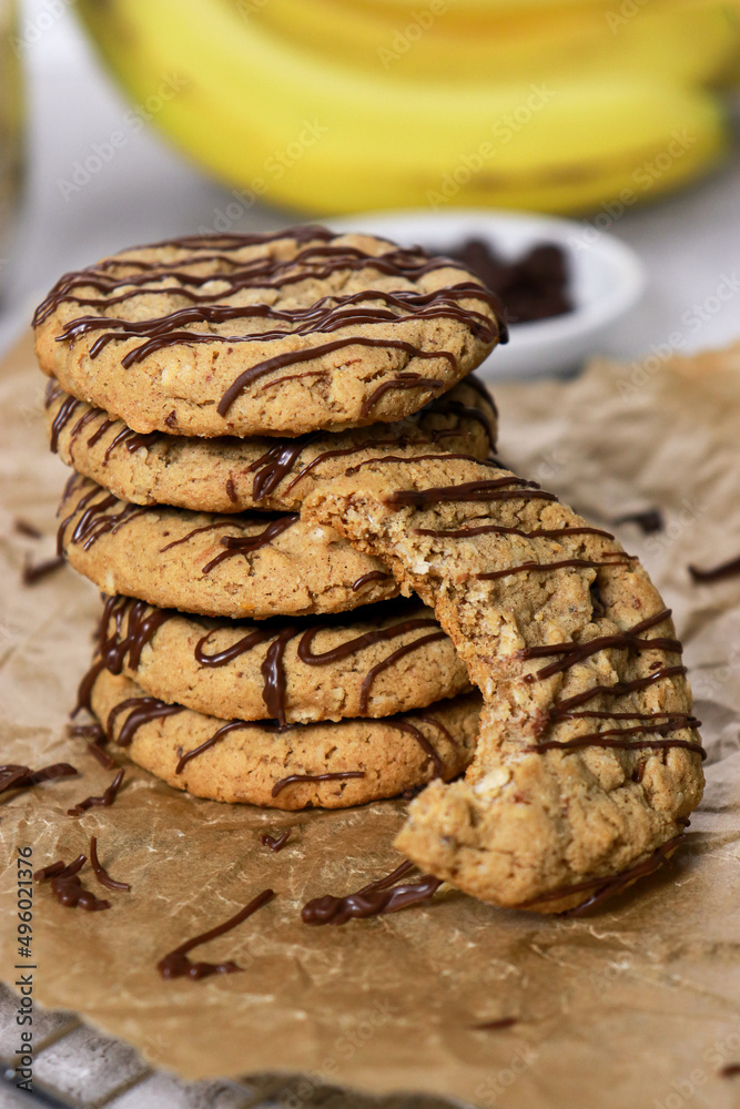 banana oatmeal cookies with chocolate chips, bananas in background banana oatmeal cookies with chocolate chips, bananas in background
