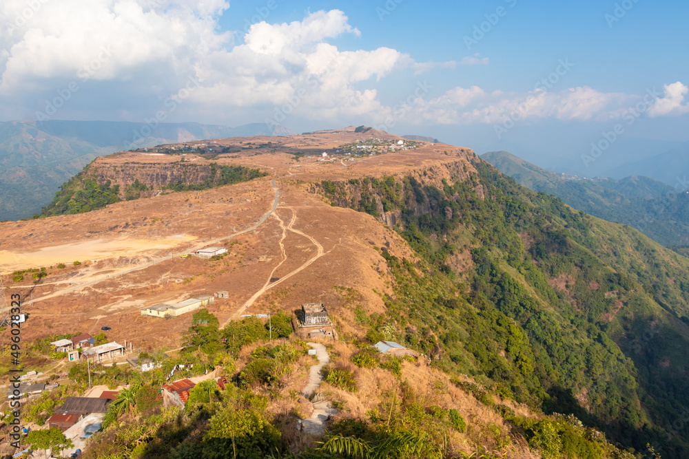 small remote village on mountain top flat bed with bright sky at morning from top angle