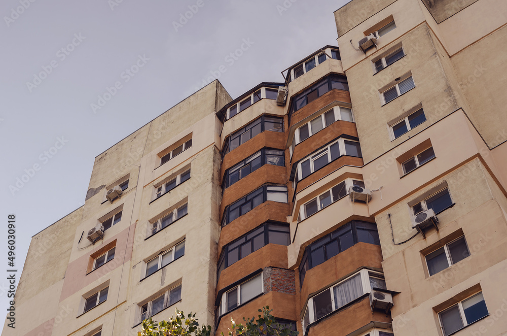 A beige building with brown balconies against the sky. High apartments or condos. Urban architecture