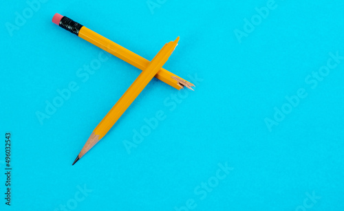 Broken pencil on blue background