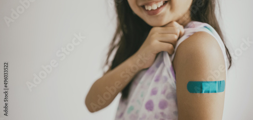 Young preteen girl showing her arm with bandage after got vaccinated or inoculation, child immunization, covid omicron vaccine concept