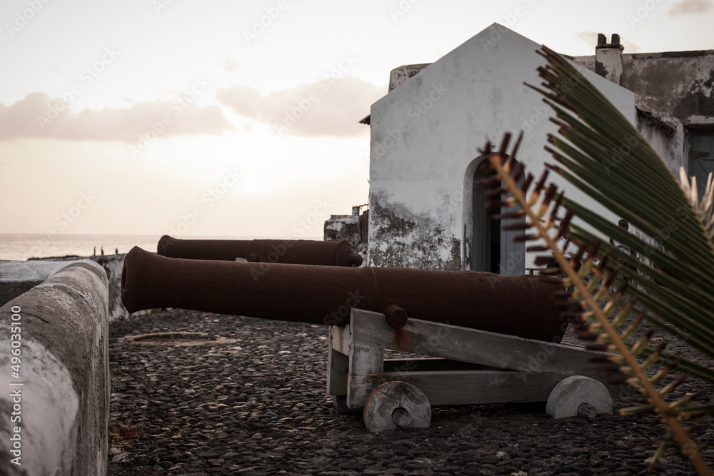 Guns or cannons outside of Lighthouse of Maria Pia with a cliff next to it, in the city of Praia, island of Santiago, Cape Verde. Guns or cannons outside of Lighthouse of Maria Pia with a cliff next to it, in the city of Praia, island of Santiago, Cape Verde.