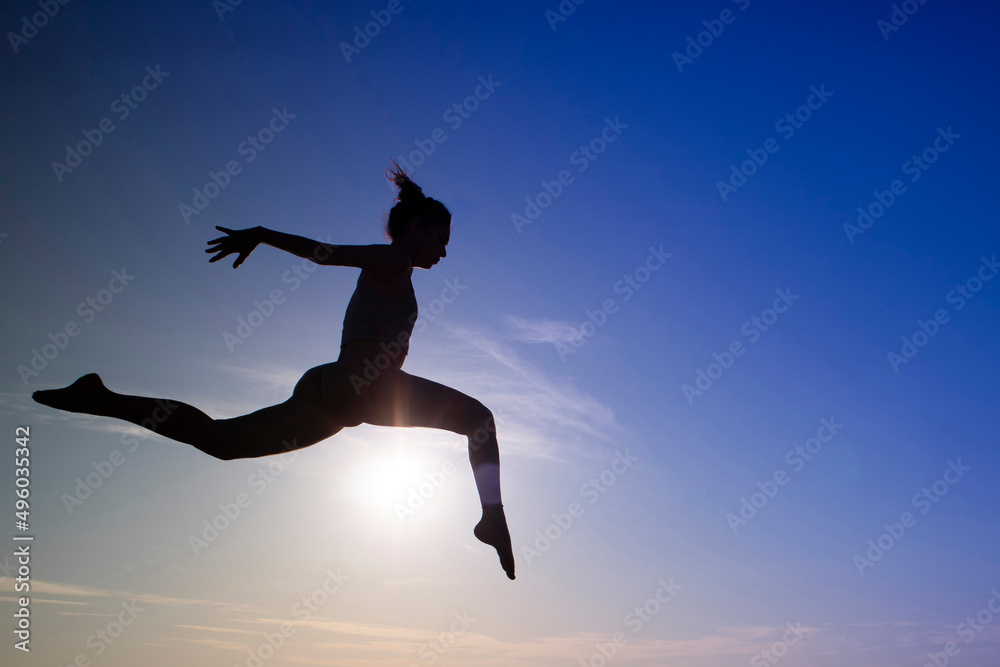 Fototapeta premium Dance jump performed outdoors in backlight