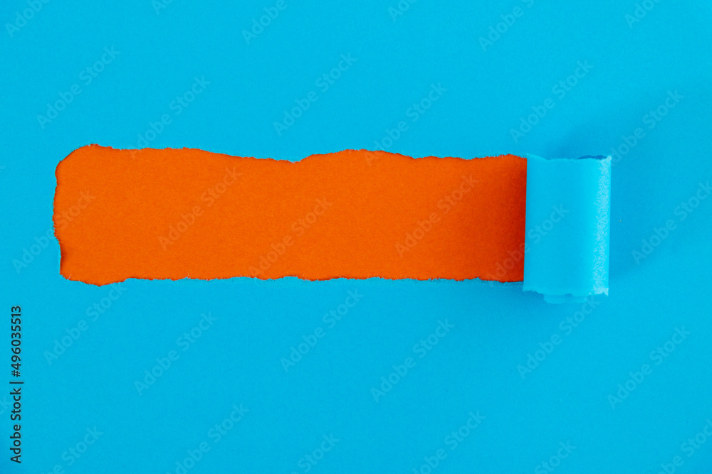 Obraz premium Blue torn paper on orange background