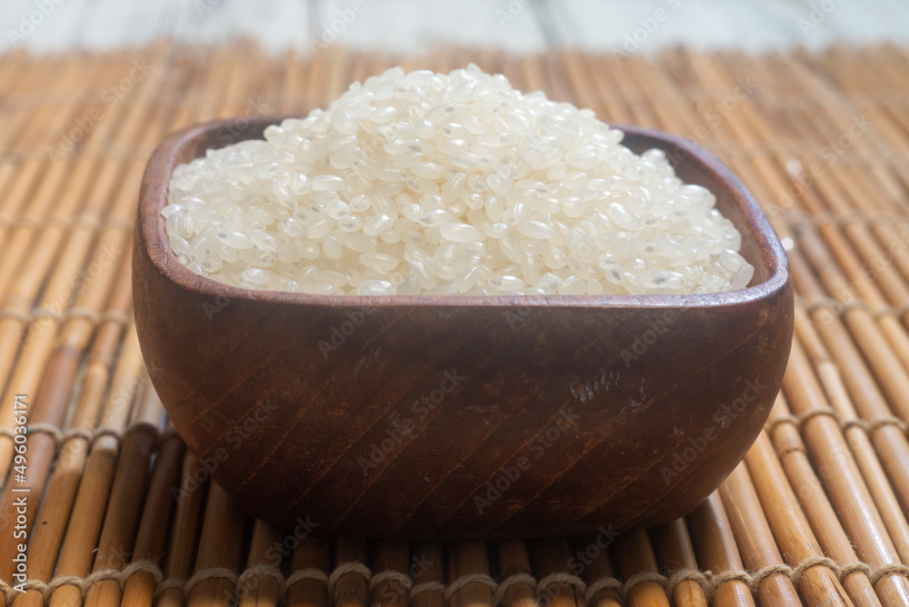 close up of japanese rice in a wooden cup. Japonica rice grains. sometimes called sinica rice, is one of the two major domestic types of Asian rice varieties. close up of japanese rice in a wooden cup. Japonica rice grains. sometimes called sinica rice, is one of the two major domestic types of Asian rice varieties.