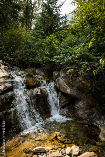 Mountain stream water falls over mossy rocks