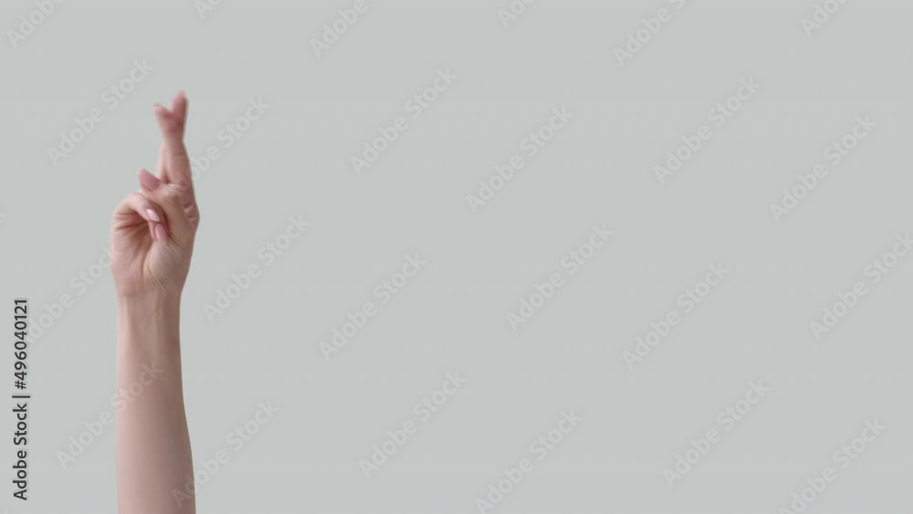 Crossed fingers. Hope chance. Wish desire. Dream opportunity. Female hands expectation gesture isolated on light neutral empty space commercial background. Crossed fingers. Hope chance. Wish desire. Dream opportunity. Female hands expectation gesture isolated on light neutral empty space commercial background.