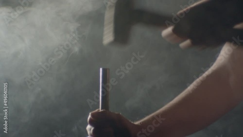 Hammer hitting a big nail in a dramatic misty ambience