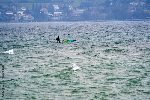 Wind surfer on Lake Geneva on a cloudy and windy spring day. Photo taken March 18th, 2022, Geneva, Switzerland.
