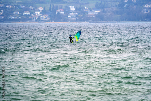 Wind surfer on Lake Geneva on a cloudy and windy spring day. Photo taken March 18th, 2022, Geneva, Switzerland.