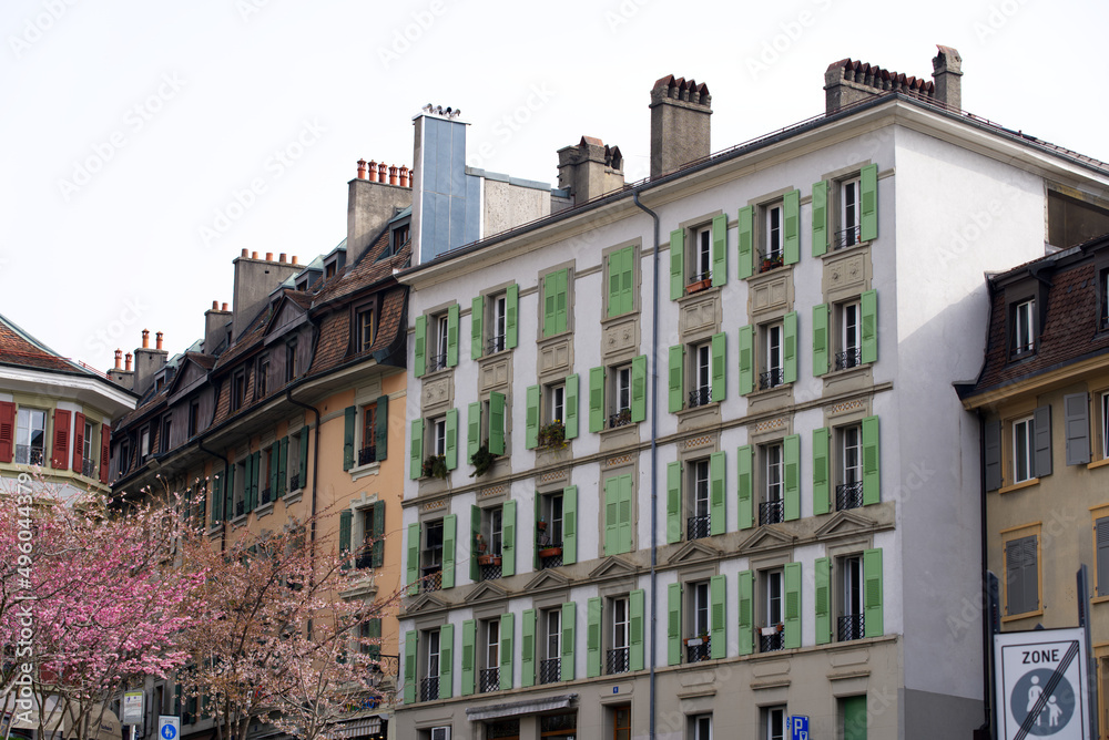 Fototapeta premium Alley and square at medieval old town of Lausanne on a blue and gray cloudy spring day with historic houses. Photo taken March 18th, 2022, Lausanne, Switzerland.