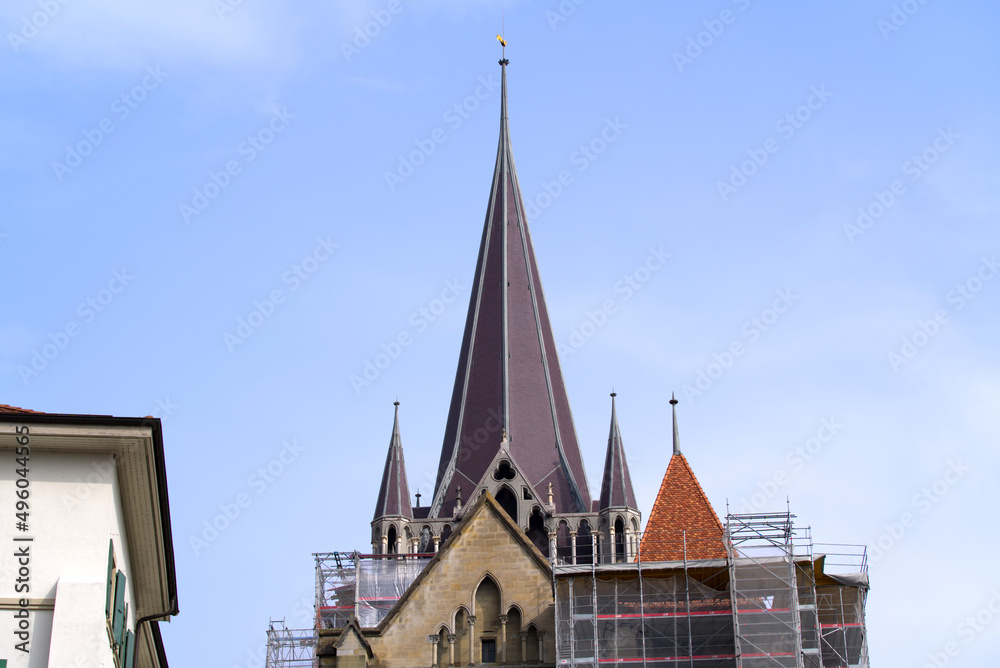 Medieval Cathedral Notre Dame at the old town of Lausanne on a blue and gray cloudy spring day. Photo taken March 18th, 2022, Lausanne, Switzerland.