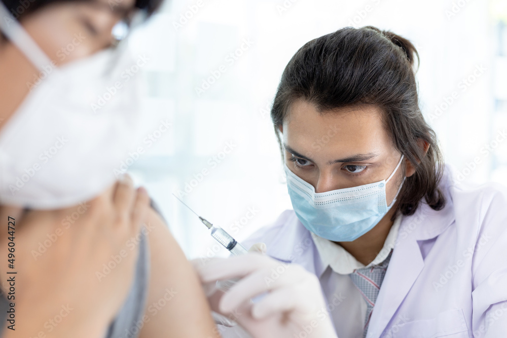Doctor vaccinating patient, vaccination against new strains of virus, Doctor holding a syringe, Antivirus vaccination for people, Covid-19, Doctor vaccinating male patient in clinic or hospital. Doctor vaccinating patient, vaccination against new strains of virus, Doctor holding a syringe, Antivirus vaccination for people, Covid-19, Doctor vaccinating male patient in clinic or hospital.