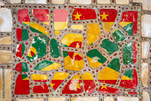 National flag of Grenada on stone wall background. Flag banner on stone texture background.