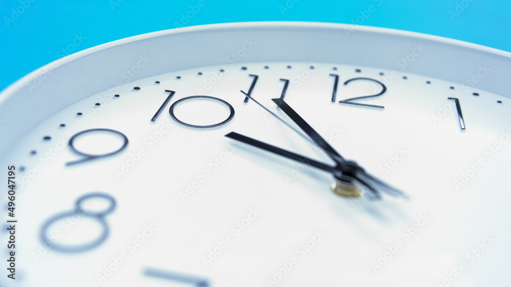 Closeup single clock hanging on blue wall