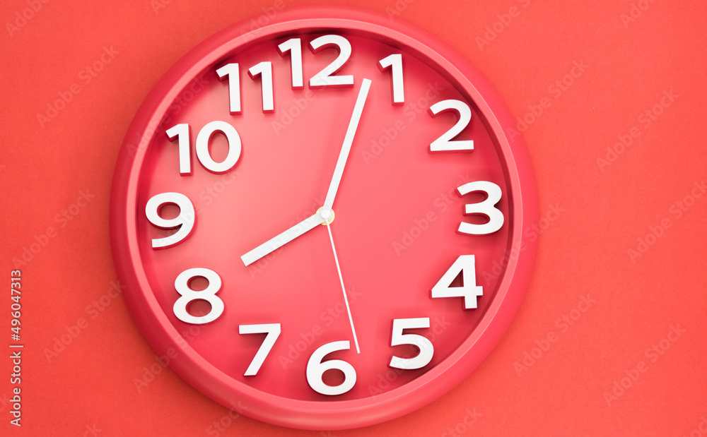 Closeup single clock hanging on red wall Closeup single clock hanging on red wall