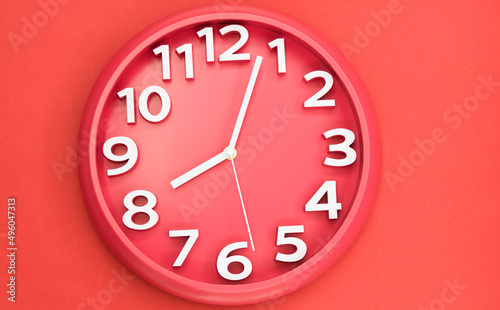 Closeup single clock hanging on red wall
