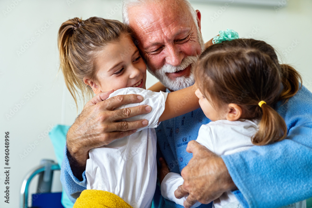 Happy laughing grandfather playing, having fun with his grandchildren together. Happy laughing grandfather playing, having fun with his grandchildren together.