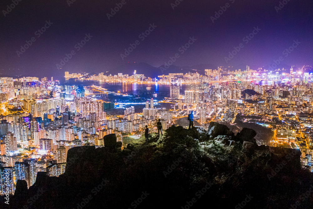 Men hiking at the Lion Rock Peak, Hong Kong night view, panorama from Kowloon district to Hong Kong Island, Asis