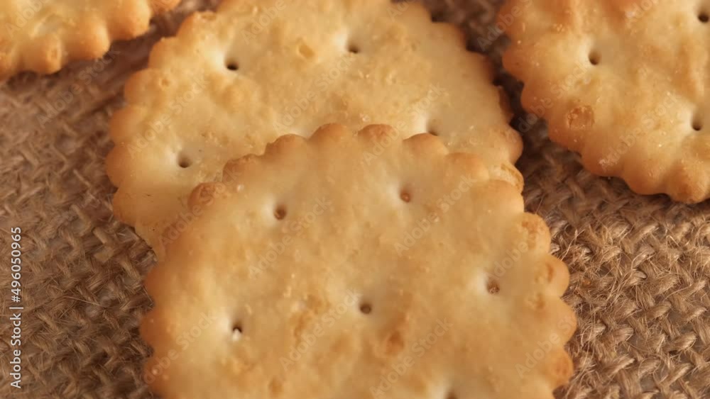 Circle crackers with salt. Close up. Rotating cracker cookies background. Tasty food. Beautiful round crackers on canvas Circle crackers with salt. Close up. Rotating cracker cookies background. Tasty food. Beautiful round crackers on canvas