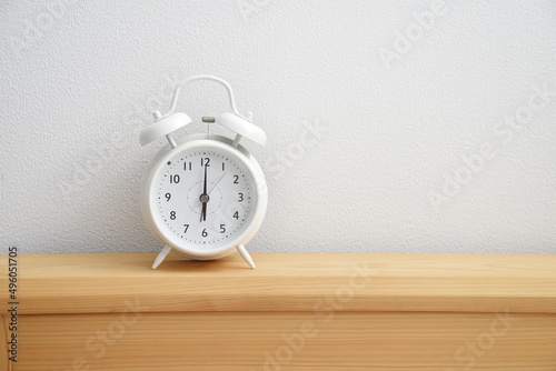 白い目覚まし時計　時計　置き時計　卓上　デスク　机　ベッド　朝　夕方　夜　時間　６時　余白　白背景　文字スペース　ホワイトスペース　コピースペース