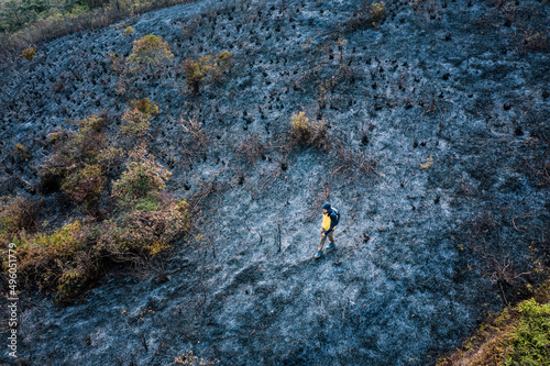 After wildfire, man walking acroos the ash field, Sai Kung, Hong Kong, Asia photo