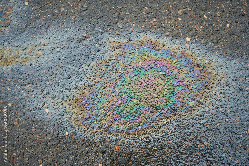 Obraz premium Oil slick on the asphalt road background