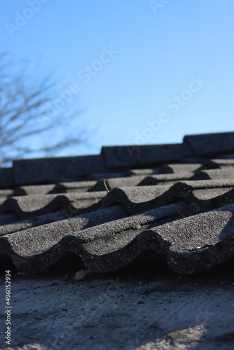 Removing Gray cement roofing tiles damaged by weather on top of a house in Italy